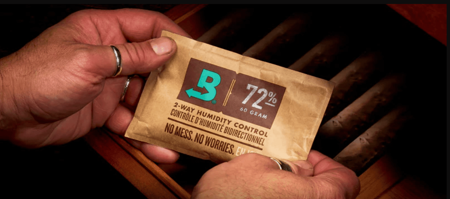 Brown glass jar with green buds on top, pile of green powder beside, leafy plants in background against a light green backdrop