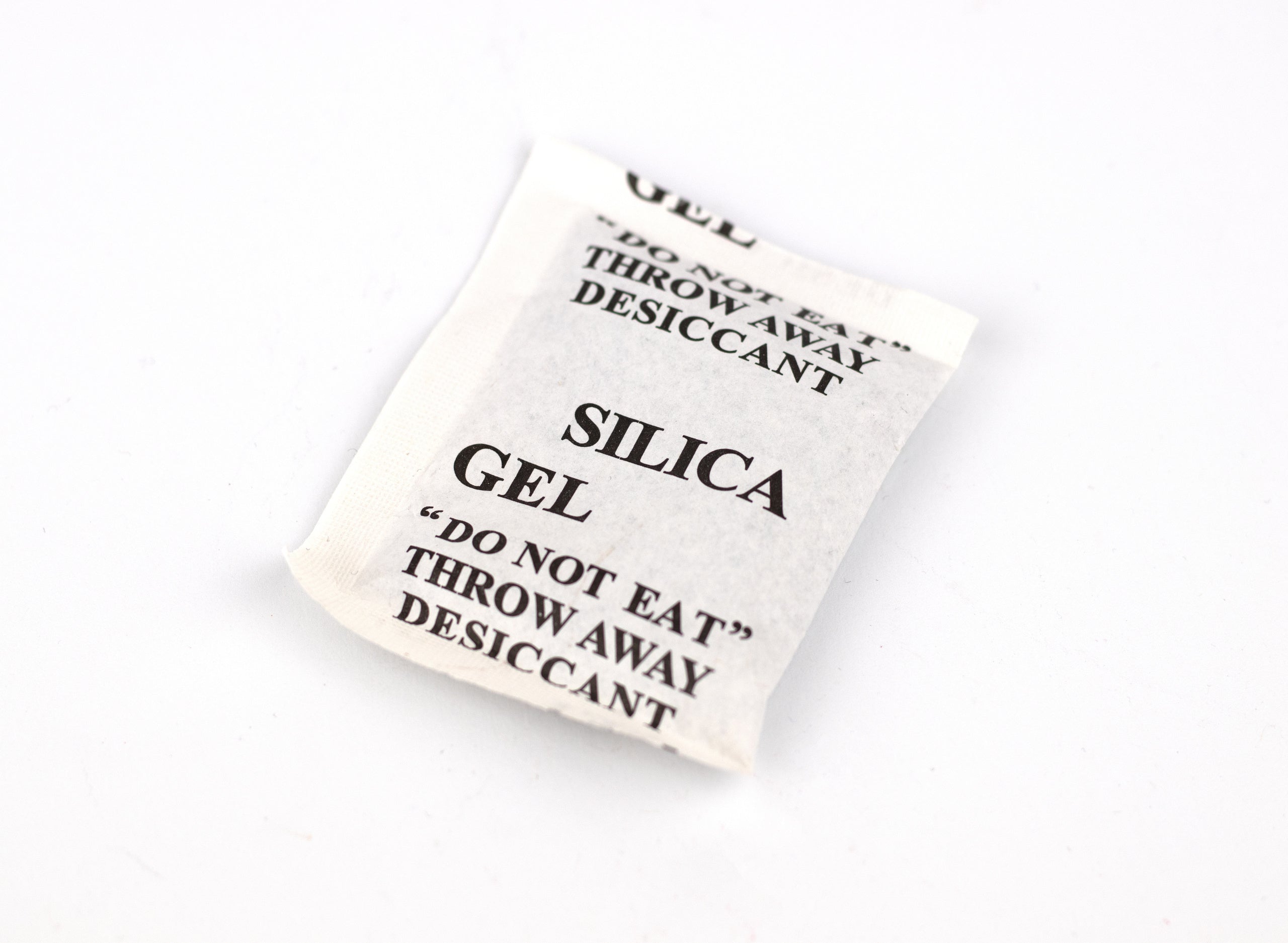 Glass jars and plastic containers filled with green, leafy buds, alongside a dropper bottle with yellow liquid, on a dark background