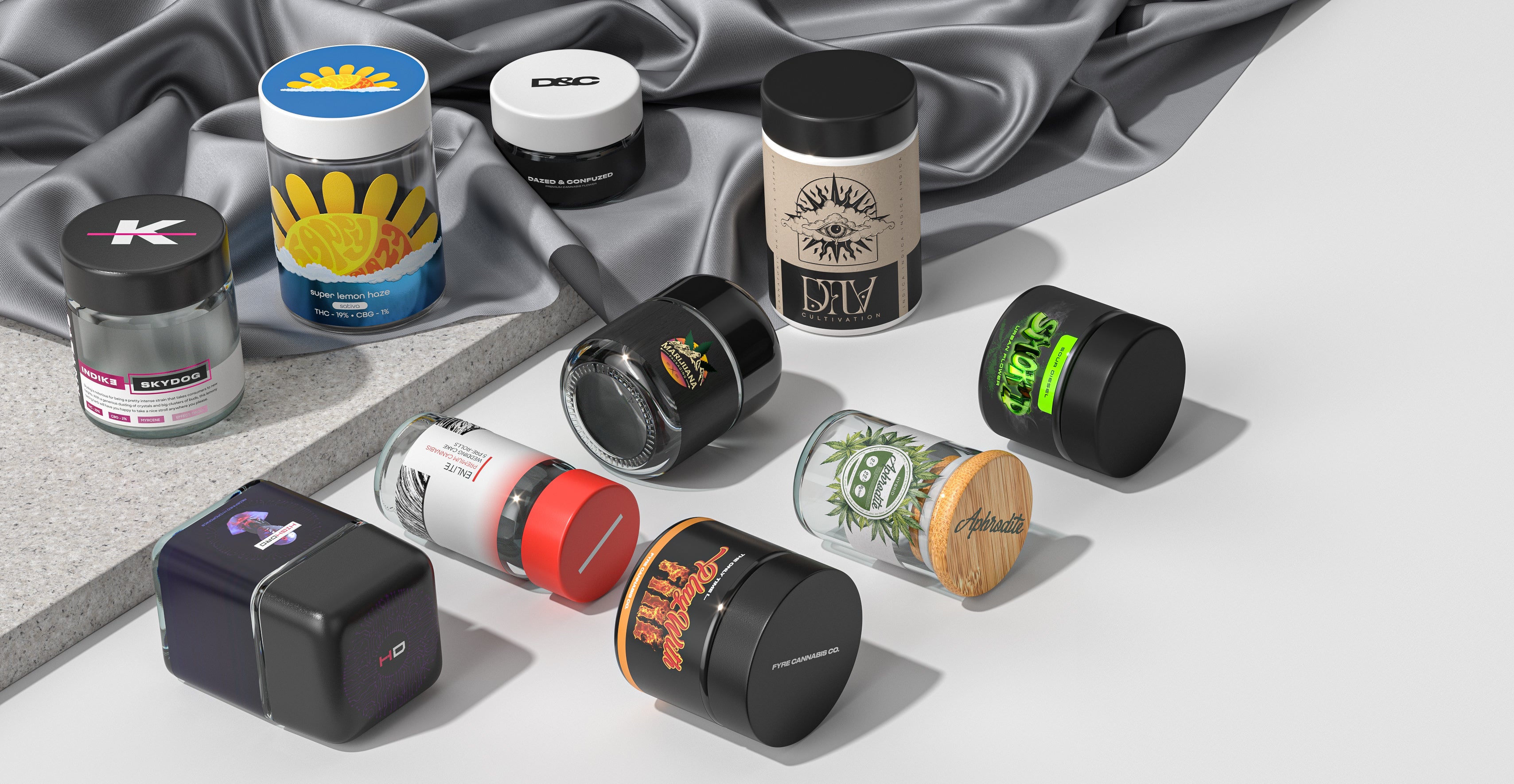 Variety of custom branded cannabis packaging products on white surface and gray cloth