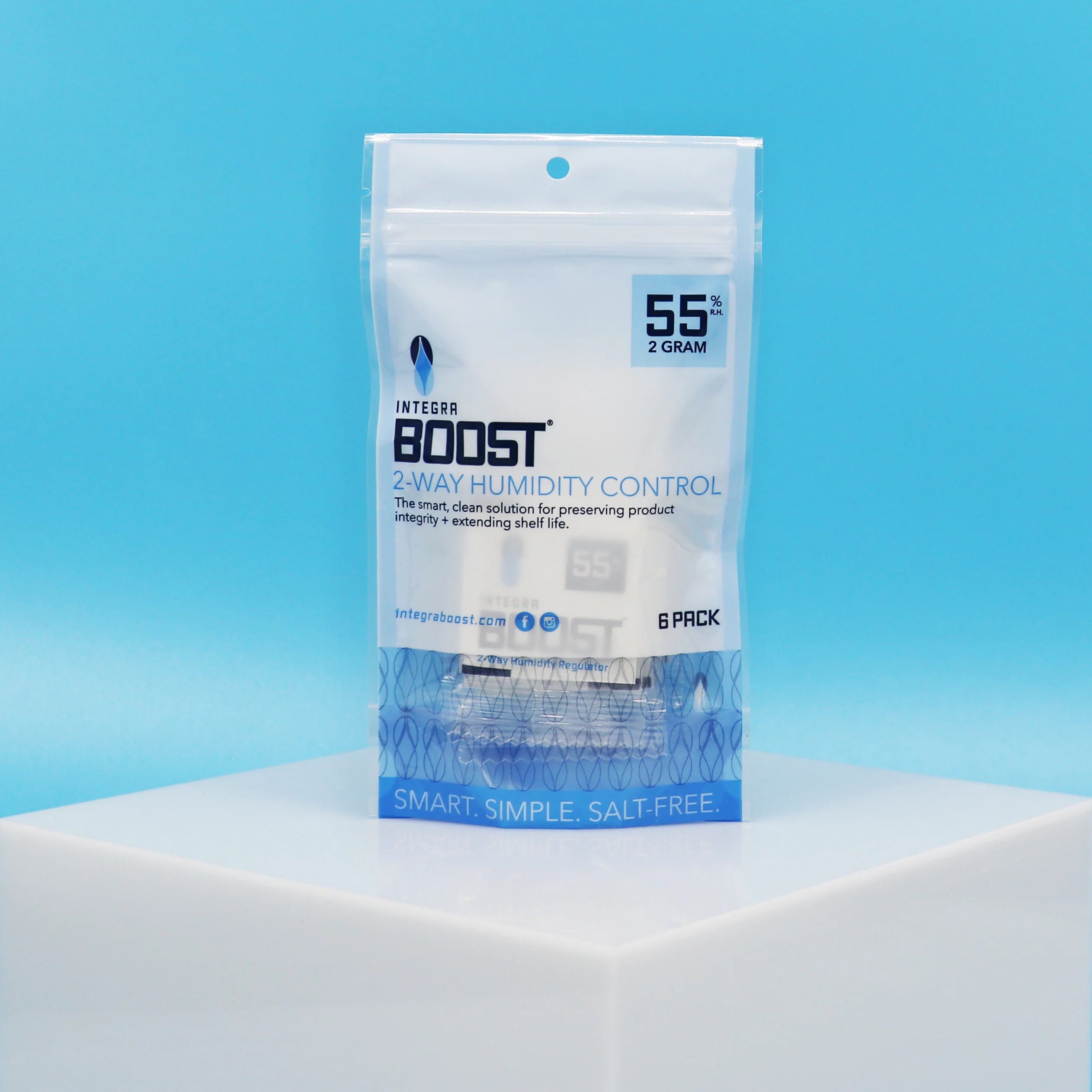 White bottles and cannabis leaves on a light surface, with a cannabis bud and water droplets in the background